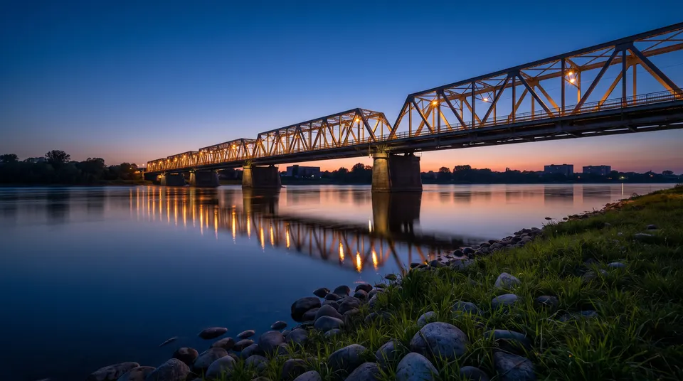 Steel truss bridge over a river at dusk